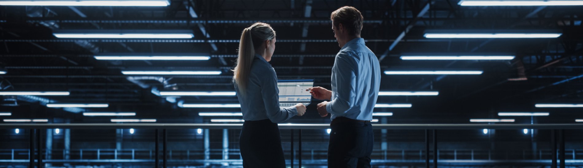 Two professionals working on cybersecurity in a computing facility.